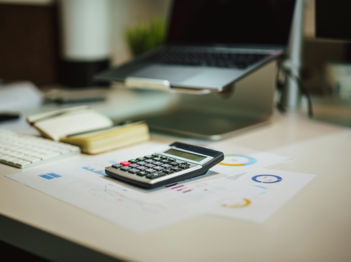 a calculator sitting on top of a table next to a laptop